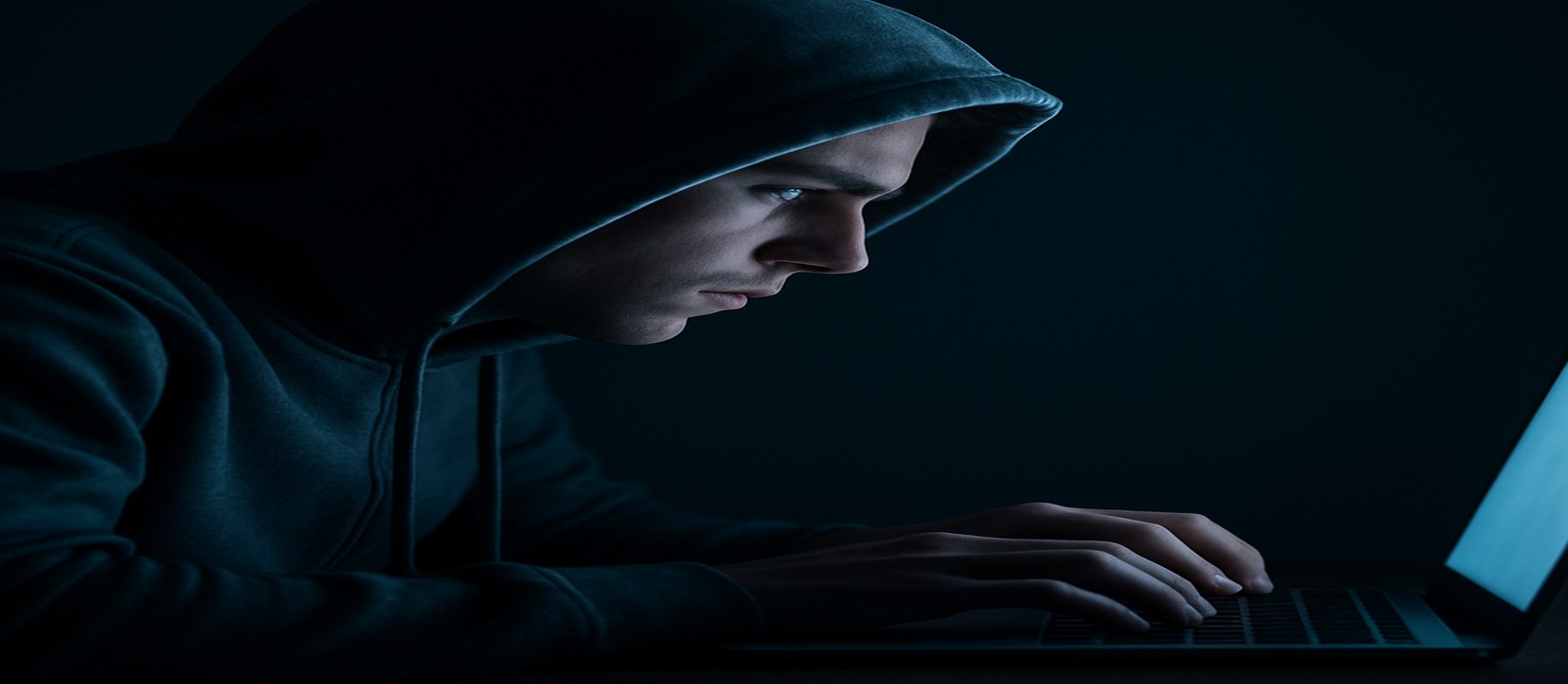db333 ওয়েবসাইটে অনলাইন গেমিংয়ে মনোযোগ দিয়ে একজন ব্যক্তি অন্ধকার ঘরে ল্যাপটপ ব্যবহার করছেন